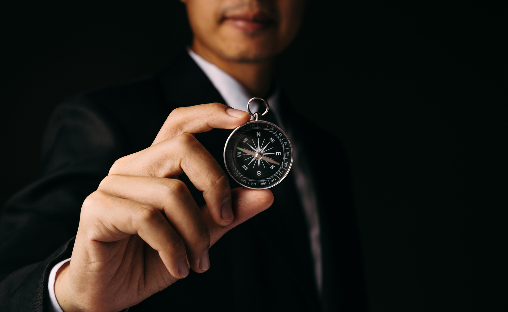 Compass in businessman hand to guide business